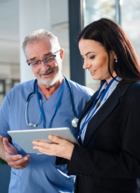 a doctor and a business woman are looking at a tablet together