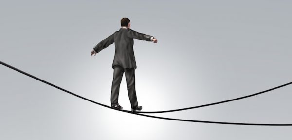 man walking across a tight rope.