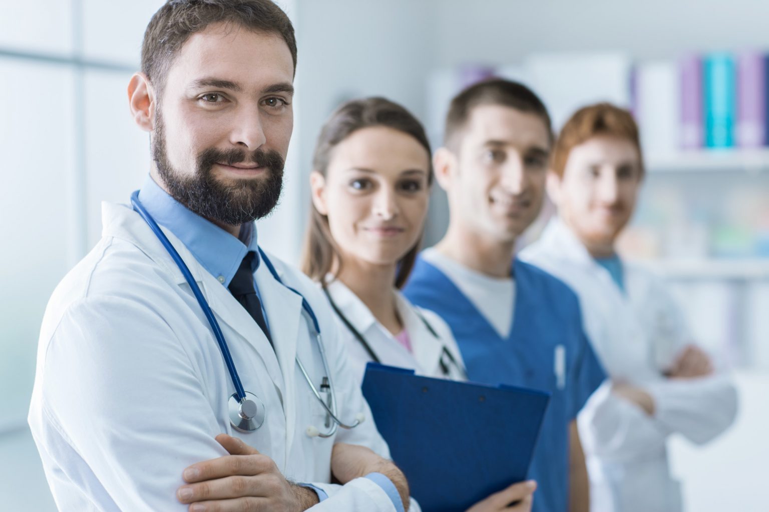 4 doctors lined up, smiling at the camera, each one becoming blurrier.