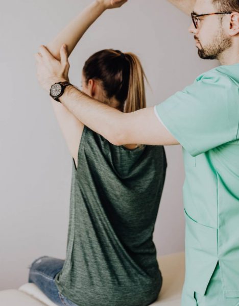 Woman stretching with a man helping her stay in place.