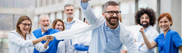 Doctor having fun with other staff, as they stretch out his coat.