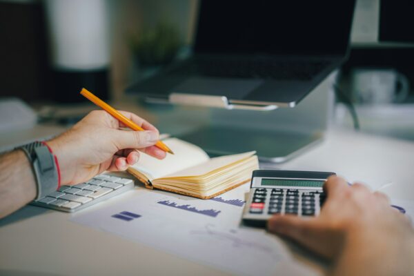 Person Holding a Calculator and Writing