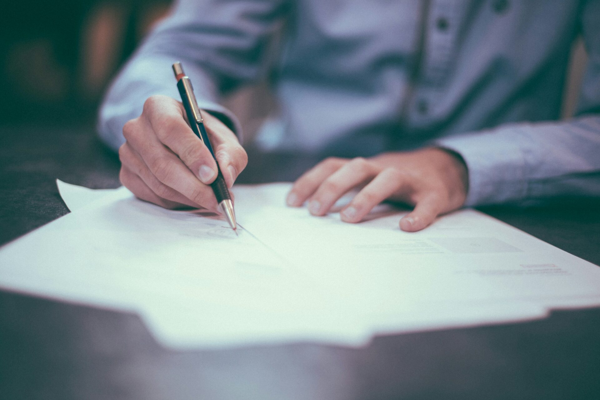 person writing on a piece of paper