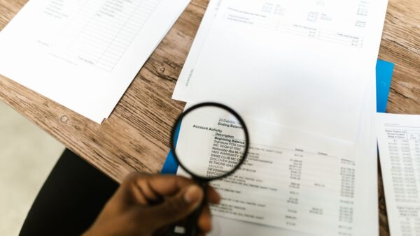 Magnifying glass reviewing documents, representing Medicare audit scrutiny