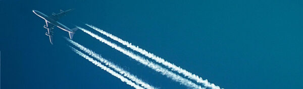 Airplane in the sky with a stream behind it.