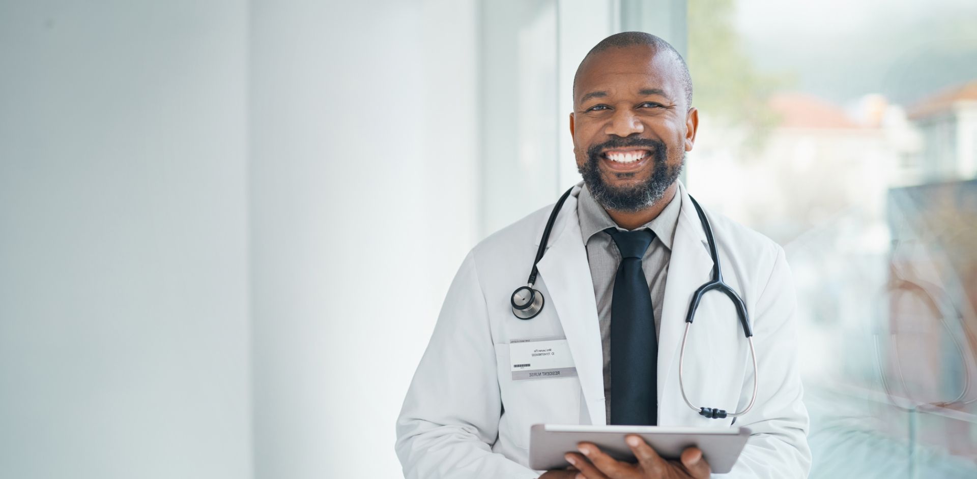 Doctor Smiling Holding a Tablet
