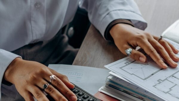 Compliance professional reviewing audit documents and analytics with calculator