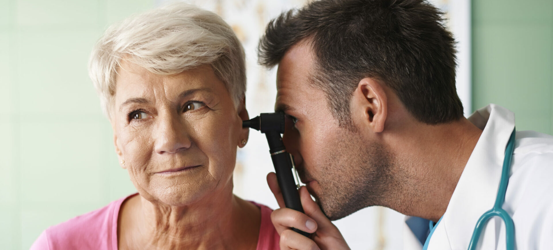 Doctor examining ear of an older woman