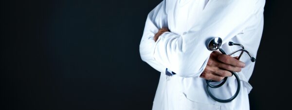 a doctor is holding a stethoscope with their arms crossed