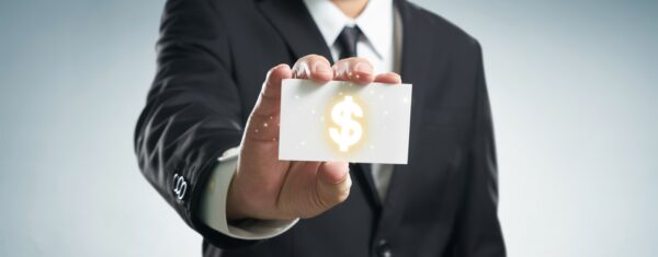 a man in a suit is holding a business card with a dollar sign on it