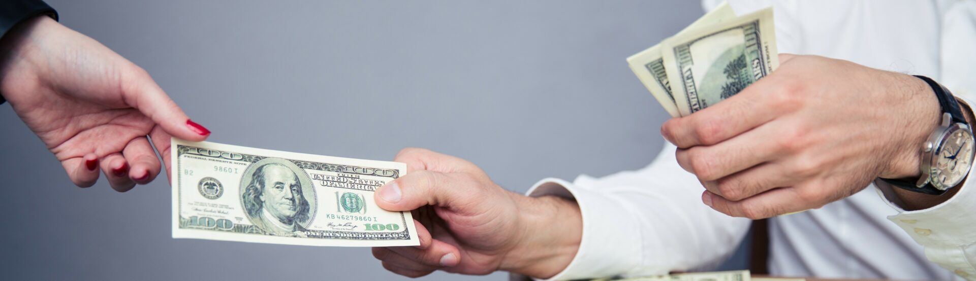 a man is handing a woman a dollar bill