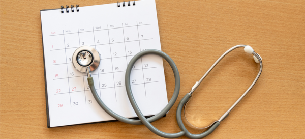 Calendar on a table with a stethoscope sitting on top.