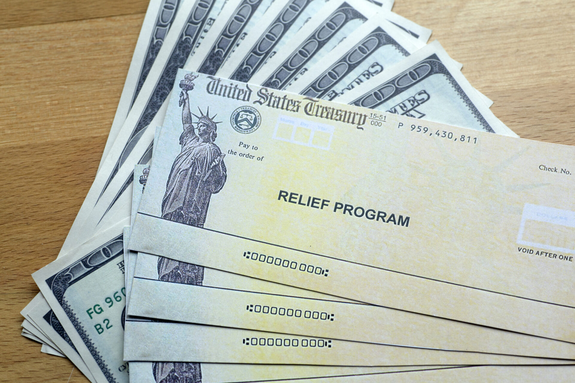 United States Treasury checks and money sitting on a table.