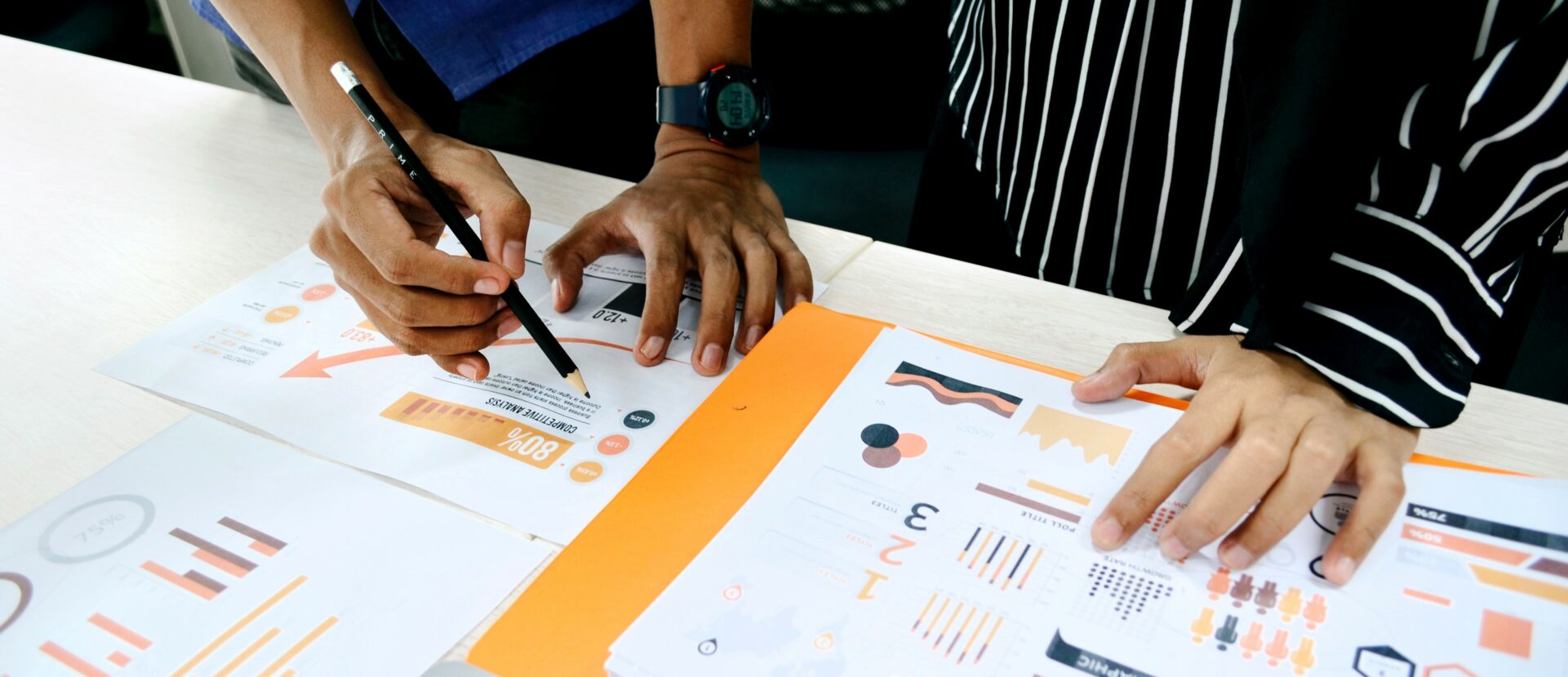a man and a woman are sitting at a table looking at papers