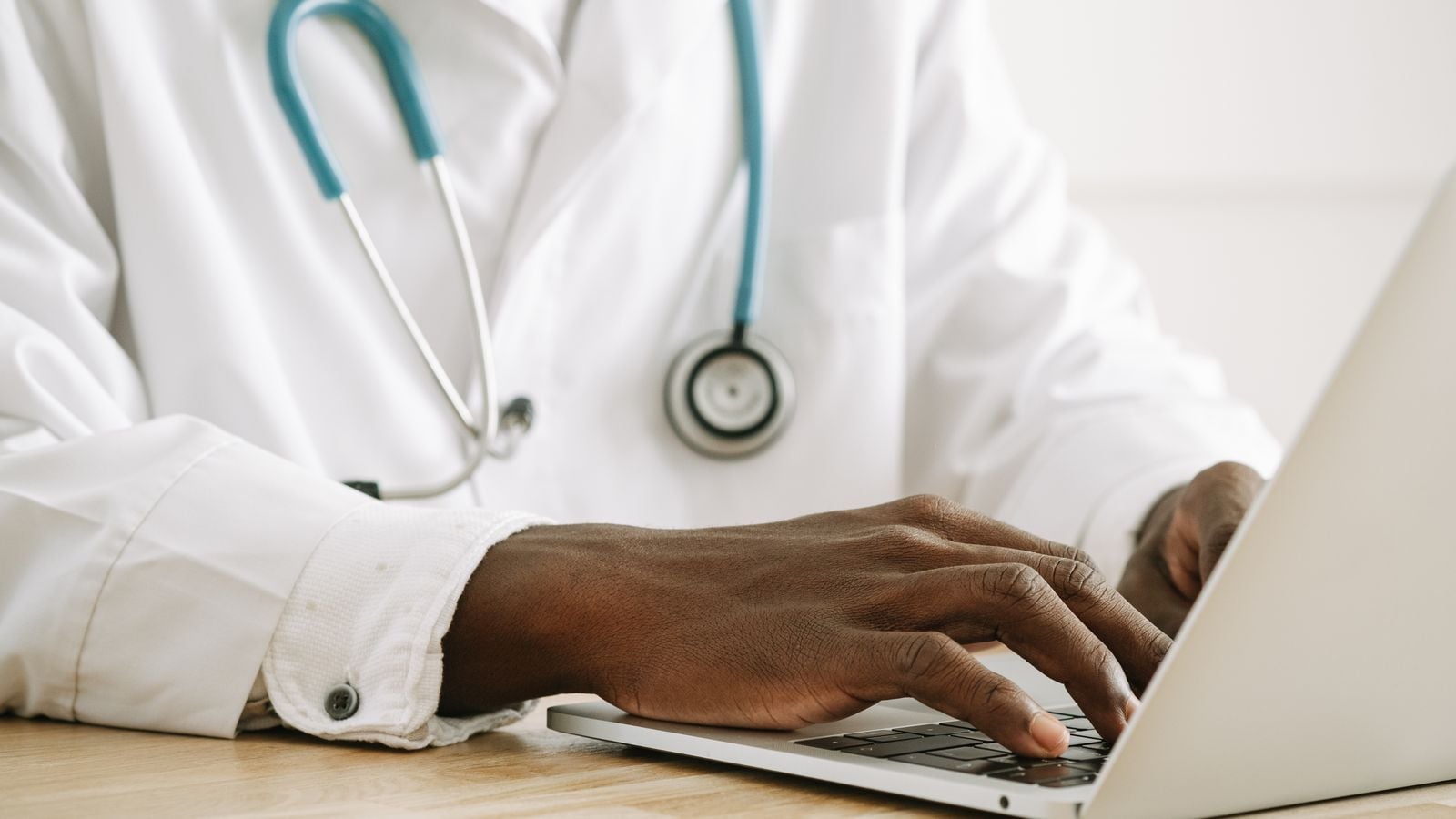 Physician using a laptop in a medical office, representing AI tools in healthcare