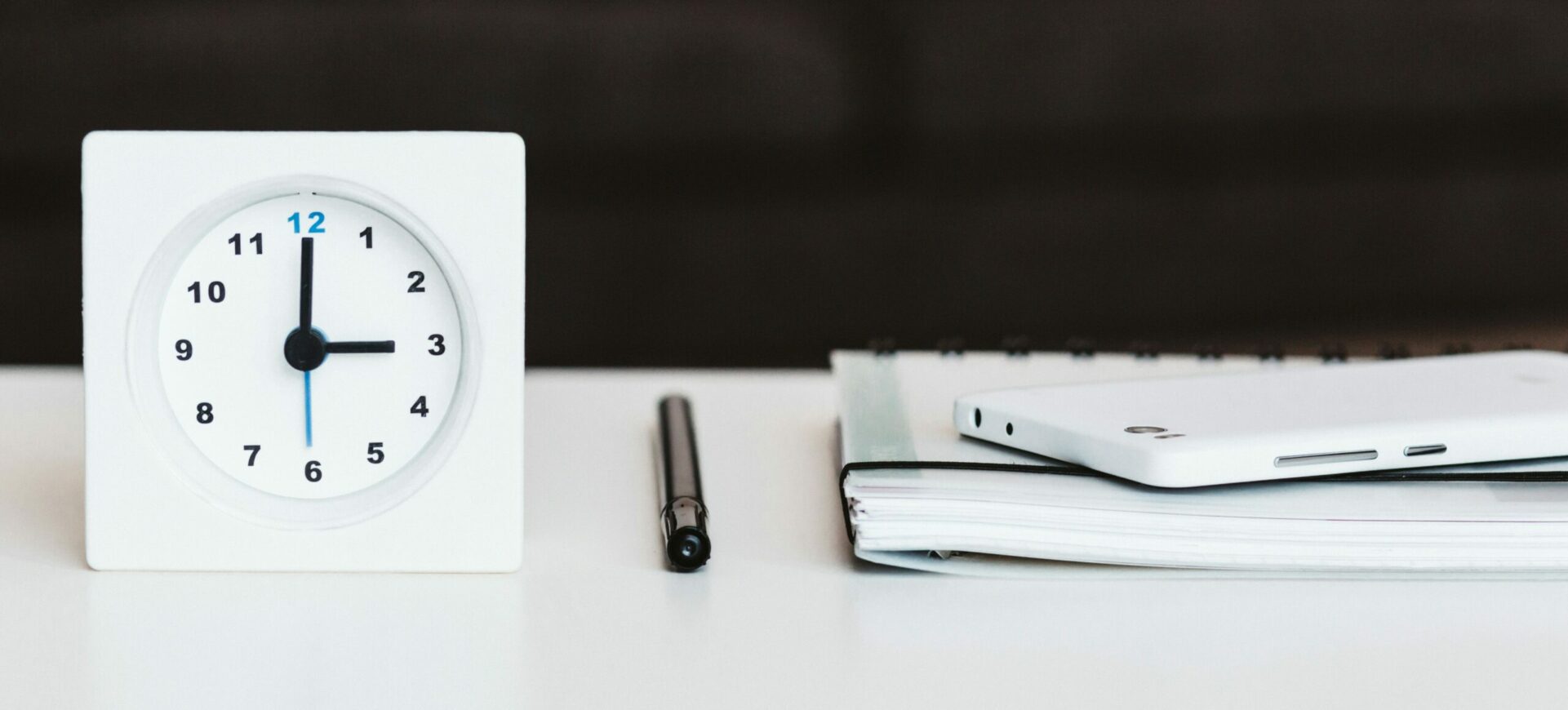 Timer Next to a Notebook and Pen