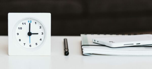 Timer Next to a Notebook and Pen